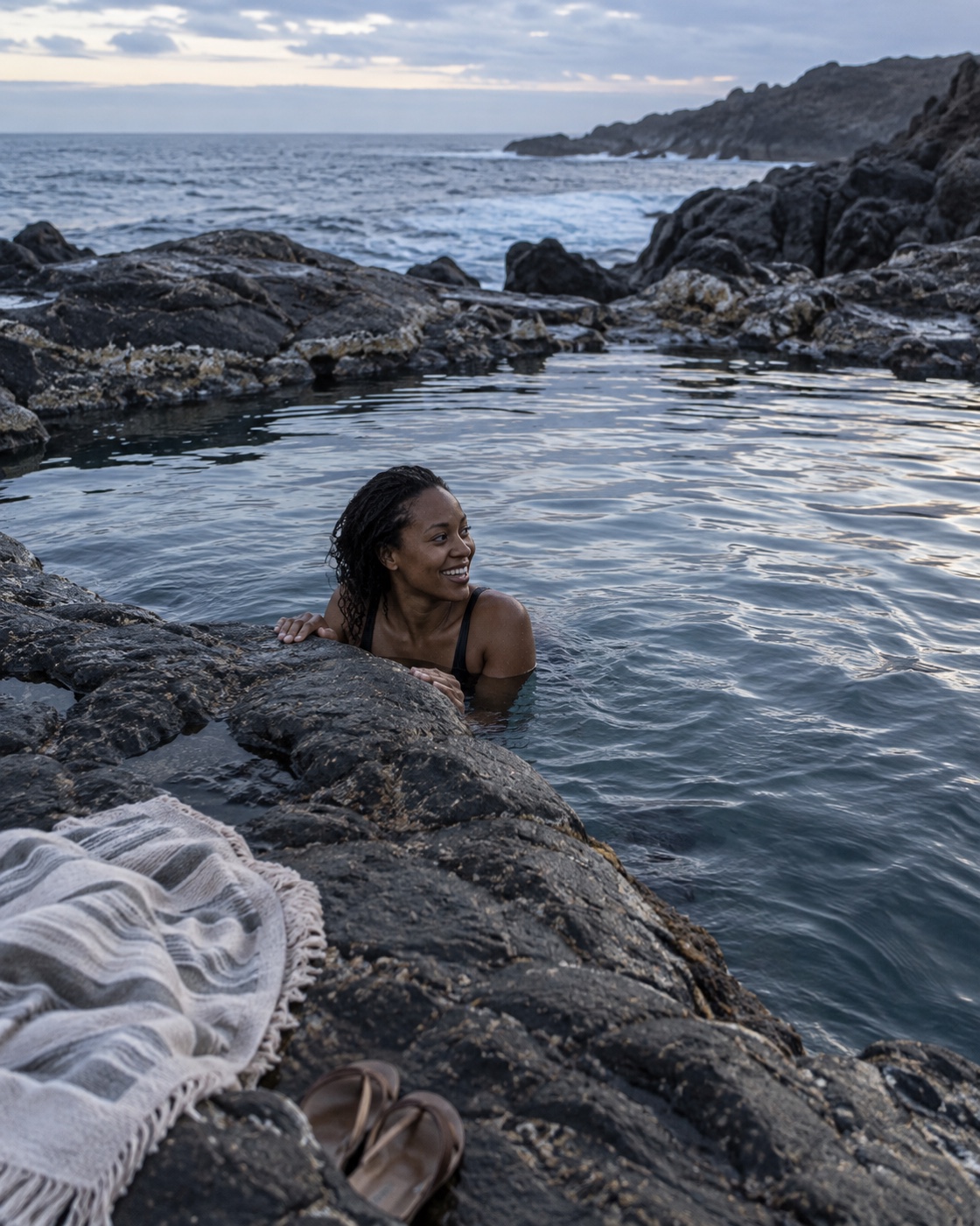 Traveler swimming in a natural coastal pool